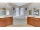 Beautiful bathroom featuring dual vanities, soaking tub, tile floors, and natural lighting at 7609 Trimming Ct, Las Vegas, NV 89149