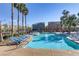 Beautiful resort-style community pool with plenty of seating and palm trees at 7609 Trimming Ct, Las Vegas, NV 89149