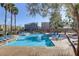 Resort-style community pool with plenty of seating and palm trees at 7609 Trimming Ct, Las Vegas, NV 89149