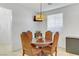 Cozy dining area with a round table, four chairs, and a unique light fixture at 7609 Trimming Ct, Las Vegas, NV 89149