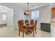 Charming dining area with round table, four upholstered chairs, and lots of natural light at 7609 Trimming Ct, Las Vegas, NV 89149