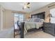 Bright main bedroom featuring a ceiling fan, large windows, and a comfortable seating area at 7609 Trimming Ct, Las Vegas, NV 89149