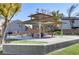 Covered picnic area with seating, surrounded by green grass and community buildings at 7609 Trimming Ct, Las Vegas, NV 89149