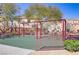 Community playground with swings, green turf, and neighborhood buildings at 7609 Trimming Ct, Las Vegas, NV 89149