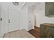 Hallway showing the front door and tile flooring leading to hardwood floors at 7722 Top Hat Ave, Las Vegas, NV 89113