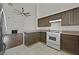 Open kitchen featuring white appliances, wood cabinets, tile floor and a view to the living room at 7722 Top Hat Ave, Las Vegas, NV 89113