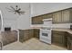 Bright kitchen features neutral stone countertops, classic white appliances and dark wood cabinets at 7722 Top Hat Ave, Las Vegas, NV 89113