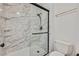 Shower showcases glass door, black shower head, built-in shelves and marble-look wall at 7722 Top Hat Ave, Las Vegas, NV 89113