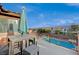 Balcony view overlooking a community pool, complete with an umbrella-shaded table and chairs, perfect for relaxation at 8093 Luna Sera Ave, Las Vegas, NV 89178
