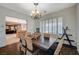 Charming dining area with chandelier, wood floors, and view into the kitchen at 8093 Luna Sera Ave, Las Vegas, NV 89178