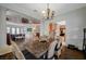 Elegant dining room with a rustic wood table, decorative lighting, and open view of the living space at 8093 Luna Sera Ave, Las Vegas, NV 89178