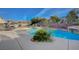 Backyard pool featuring lush landscaping, rock features, a tanning ledge, and a detached barbecue grill area at 8093 Luna Sera Ave, Las Vegas, NV 89178