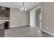 Dining room with hardwood floors and modern chandelier with natural light from sliding glass door at 8520 Insignia Ave # 104, Las Vegas, NV 89178