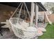 Cozy covered patio with a swing chair, comfortable seating, and lush artificial grass at 8890 Bonneville Peak Ct, Las Vegas, NV 89148
