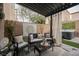 Backyard patio features an outdoor lounge area, lush faux grass, and a hot tub under a pergola at 8890 Bonneville Peak Ct, Las Vegas, NV 89148