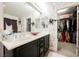 Bright bathroom with dual sinks, granite countertop, decorative fixtures, and a view into the closet at 8890 Bonneville Peak Ct, Las Vegas, NV 89148
