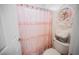 Cozy bathroom showcasing a pink shower curtain and decorative floral accents at 8890 Bonneville Peak Ct, Las Vegas, NV 89148