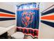 Close-up of a Chicago Bears themed shower curtain in bathroom with coordinating striped paint on walls at 8890 Bonneville Peak Ct, Las Vegas, NV 89148