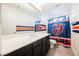 Neutral bathroom features a double sink vanity and fun Chicago Bears themed decor and shower curtain at 8890 Bonneville Peak Ct, Las Vegas, NV 89148