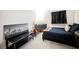 A modern bedroom with neutral colored walls, a black writing desk and guitars on a stand at 8890 Bonneville Peak Ct, Las Vegas, NV 89148