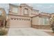 Two-story home with a two-car garage and stone facade, complemented by a well-kept front yard at 8890 Bonneville Peak Ct, Las Vegas, NV 89148