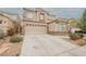Spacious two-story home with a two-car garage and stone accents, featuring a wide driveway at 8890 Bonneville Peak Ct, Las Vegas, NV 89148