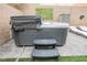 Backyard patio features a modern hot tub with steps and faux ivy on the brick wall at 8890 Bonneville Peak Ct, Las Vegas, NV 89148