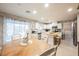 Bright kitchen features an island with seating, white cabinetry, stainless steel appliances, and a dining table with seating at 8890 Bonneville Peak Ct, Las Vegas, NV 89148
