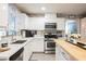 Bright kitchen with white cabinetry, stainless steel appliances, white countertops, and a butcher block island at 8890 Bonneville Peak Ct, Las Vegas, NV 89148
