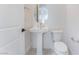 Modern powder room features a pedestal sink, oval mirror, and white fixtures with a clean design at 8979 Rolling Pietra St, Las Vegas, NV 89166