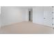 An empty bedroom with neutral carpet, white walls, and a closet and door at 8979 Rolling Pietra St, Las Vegas, NV 89166