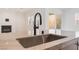 Close-up of a sleek kitchen sink with a modern black faucet and marble countertop, enhancing the contemporary design at 8979 Rolling Pietra St, Las Vegas, NV 89166