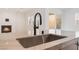 Close-up of a sleek kitchen sink with a modern black faucet and marble countertop, enhancing the contemporary design at 8979 Rolling Pietra St, Las Vegas, NV 89166