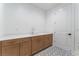 Featuring a laundry room with cabinets, sink, tile floors, and a door at 8979 Rolling Pietra St, Las Vegas, NV 89166
