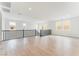 Spacious living room boasts wood floors, natural light, and staircase with black railing, creating a warm ambiance at 8979 Rolling Pietra St, Las Vegas, NV 89166