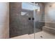 Walk-in shower boasts sleek gray tiling, rain shower head, and seamless glass enclosure for a spa-like experience at 8979 Rolling Pietra St, Las Vegas, NV 89166