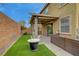 Backyard with artificial turf, covered patio, outdoor seating, grill, and access to the house at 9180 Wine Cellar Ave, Las Vegas, NV 89148
