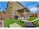 Backyard boasts a covered patio, artificial turf, a grill, and comfortable lounge seating for outdoor relaxation at 9180 Wine Cellar Ave, Las Vegas, NV 89148