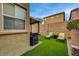 Landscaped backyard featuring artificial turf, a covered patio, a grill, and lounge chairs at 9180 Wine Cellar Ave, Las Vegas, NV 89148