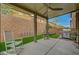 This backyard features an open patio, rocking chairs, and artificial grass at 9180 Wine Cellar Ave, Las Vegas, NV 89148