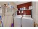 Laundry room has a washer, dryer, and shelves for storing supplies at 9180 Wine Cellar Ave, Las Vegas, NV 89148