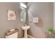 Charming powder room featuring a pedestal sink, oval mirror, and stylish decor at 9180 Wine Cellar Ave, Las Vegas, NV 89148