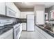 Bright kitchen with white cabinetry, granite countertops, tile floors, and stainless steel sink at 9303 Gilcrease Ave # 1013, Las Vegas, NV 89149