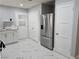 Bright kitchen featuring stainless steel appliances, modern countertops, white cabinets, and tiled flooring at 1021 Wengert Ave, Las Vegas, NV 89104