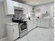 Bright kitchen featuring stainless steel appliances, modern countertops, white cabinets, and tiled flooring at 1021 Wengert Ave, Las Vegas, NV 89104