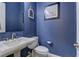 Stylish half-bathroom with blue walls, a pedestal sink, and modern fixtures offering a chic and functional space at 12121 Cabo Rojo Ave, Las Vegas, NV 89138