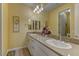 Bright bathroom featuring double sinks with neutral counters and warm yellow walls, offering a serene, inviting feel at 12121 Cabo Rojo Ave, Las Vegas, NV 89138