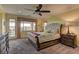 Spacious bedroom with a tufted headboard bed, dark wood furniture, and sliding door to a patio area at 12121 Cabo Rojo Ave, Las Vegas, NV 89138