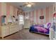 Whimsical bedroom with vertical pink stripes, elegant white furniture, and a window offering natural light at 12121 Cabo Rojo Ave, Las Vegas, NV 89138