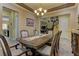 Elegant dining room featuring a chandelier, staircase, and view into the kitchen for a welcoming gathering space at 12121 Cabo Rojo Ave, Las Vegas, NV 89138